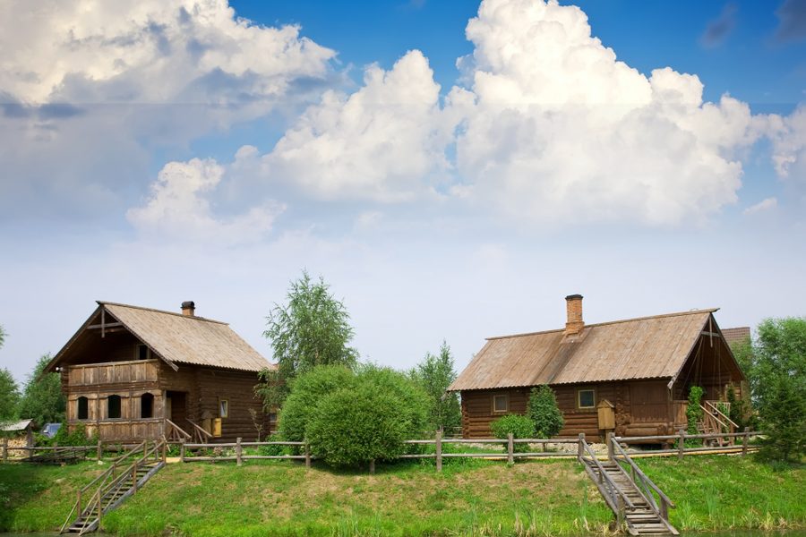 Pozycjonowanie agroturystyki — drewniane domy gospodarstwa agroturystycznego nad stawem