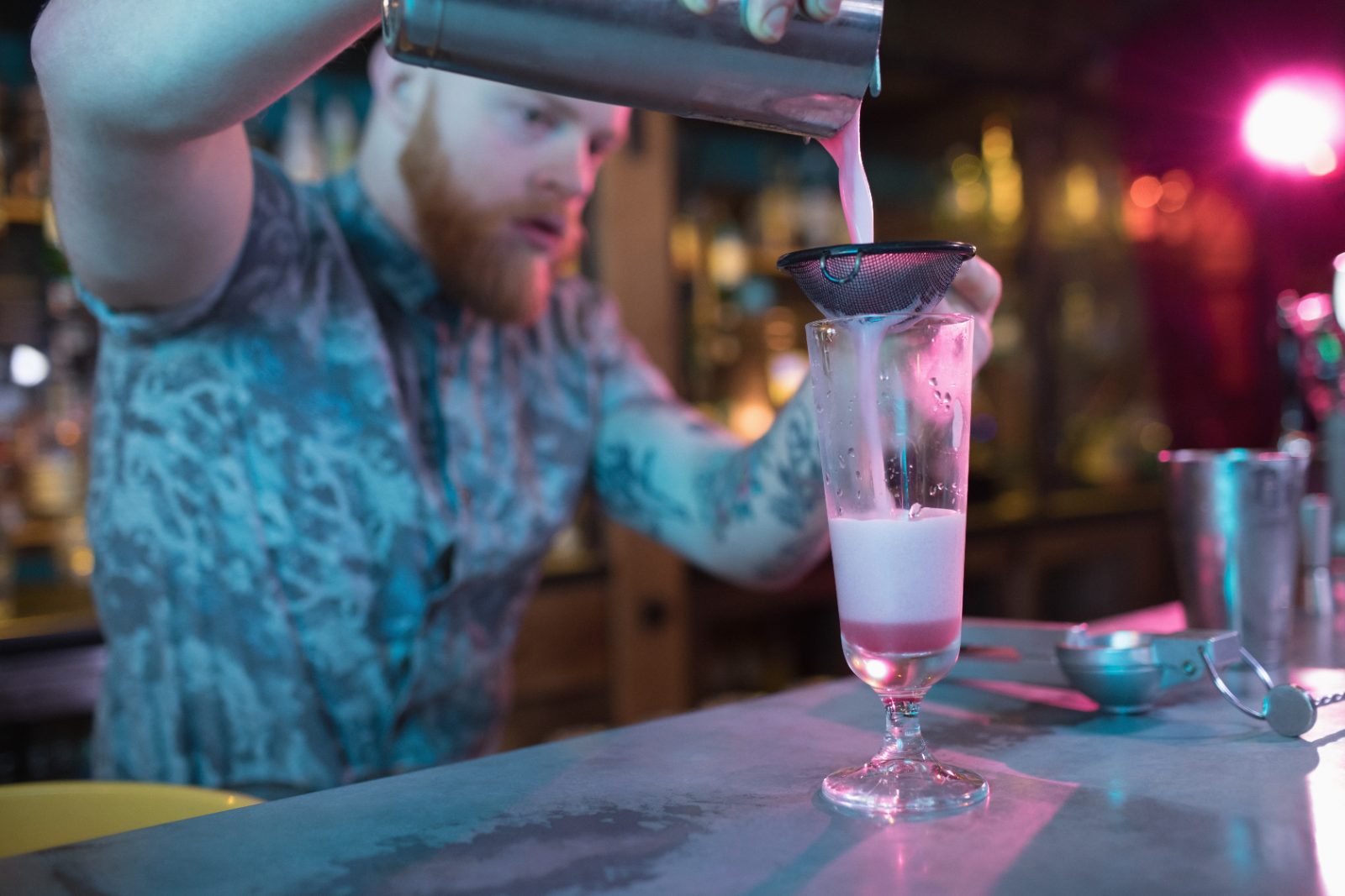 Pozycjonowanie barmana i mobilnego baru - barman przygotowujący koktajl przy ladzie