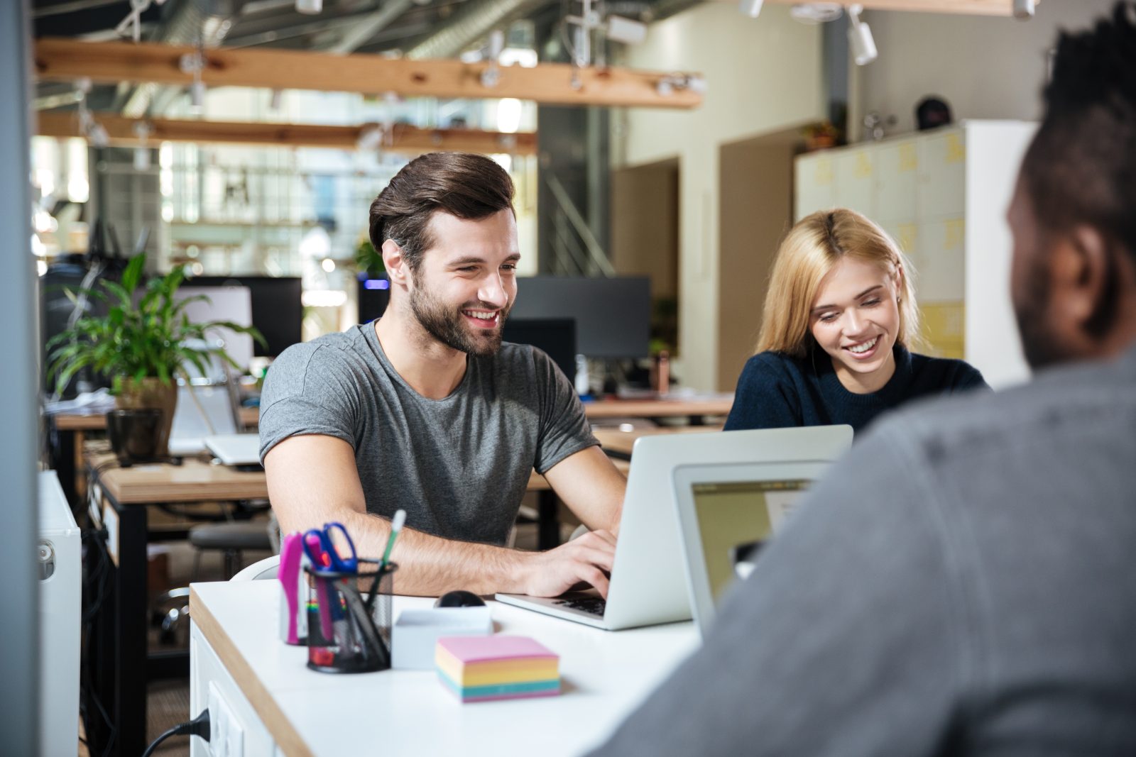 Pozycjonowanie coworkingu i wirtualnego biura - troje młodych osób pracuje przy laptopach we wspólnej przestrzeni biurowej