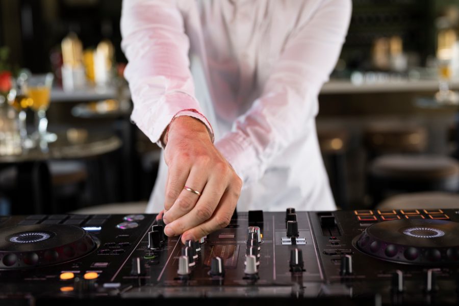 Pozycjonowanie DJ-a na wesele - didżej przy konsolecie i bawiący się goście