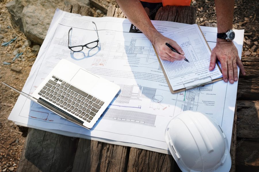 Pozycjonowanie geodety — geodeta z tachimetrem podczas pomiarów w terenie