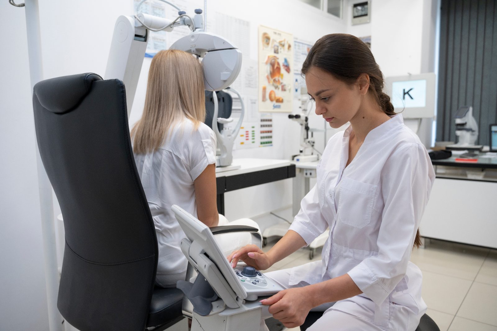 Pozycjonowanie optometrysty - optometrystka obsługuje urządzenie do badania wzroku, pacjentka patrzy w aparat