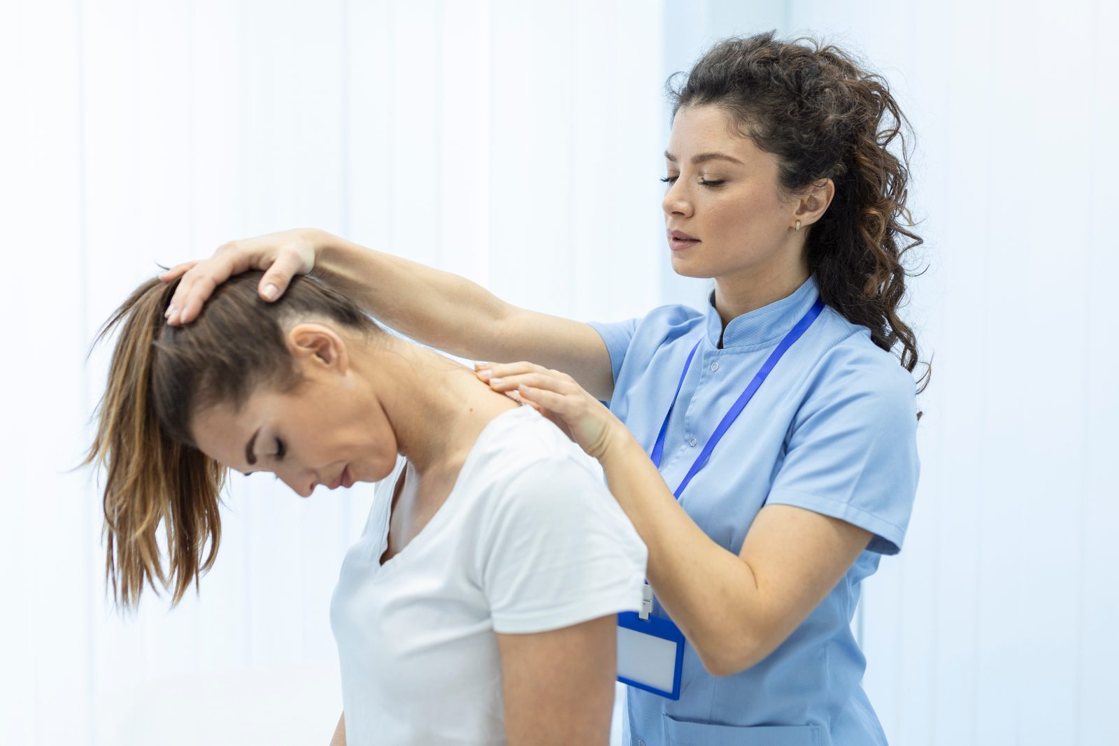 Pozycjonowanie osteopaty - terapeutka wykonuje terapię manualną szyi pacjentki w gabinecie