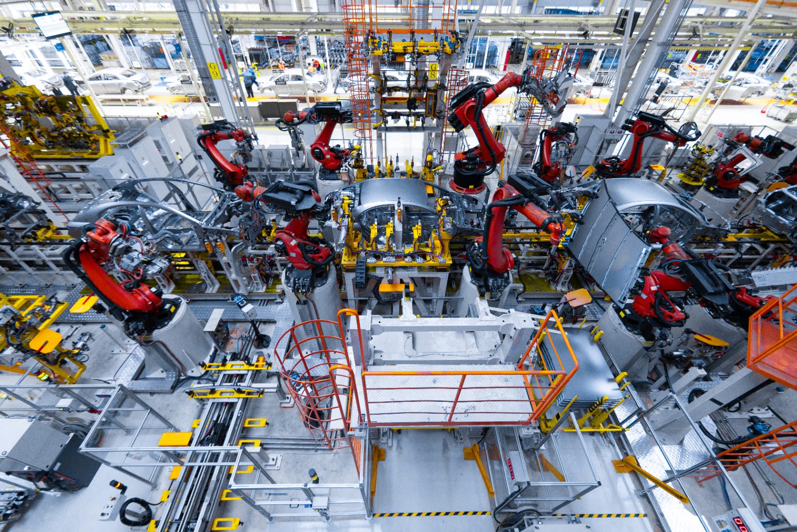 Pozycjonowanie robotyzacji przemysłowej - ramiona robotów pracujące na linii produkcyjnej w hali