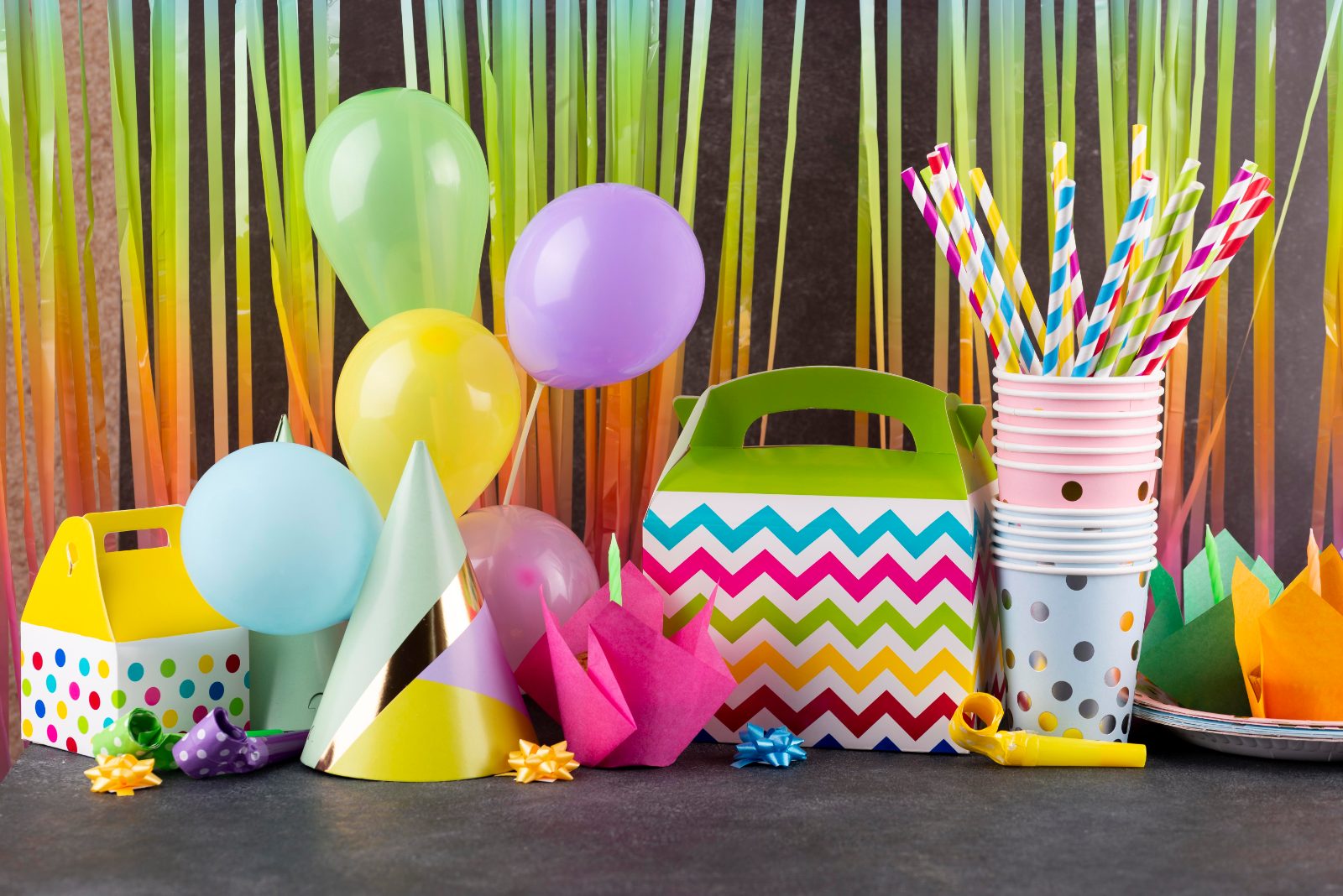 Balony, kubki i dekoracje imprezowe rozłożone na blacie