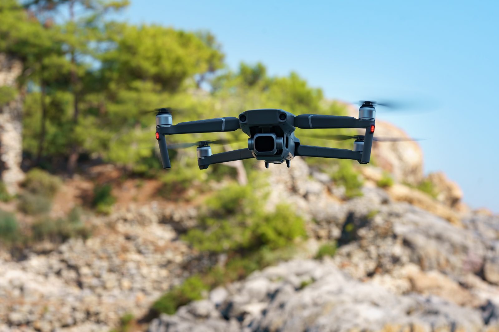 Dron z kamera stojacy na skale nad dolina