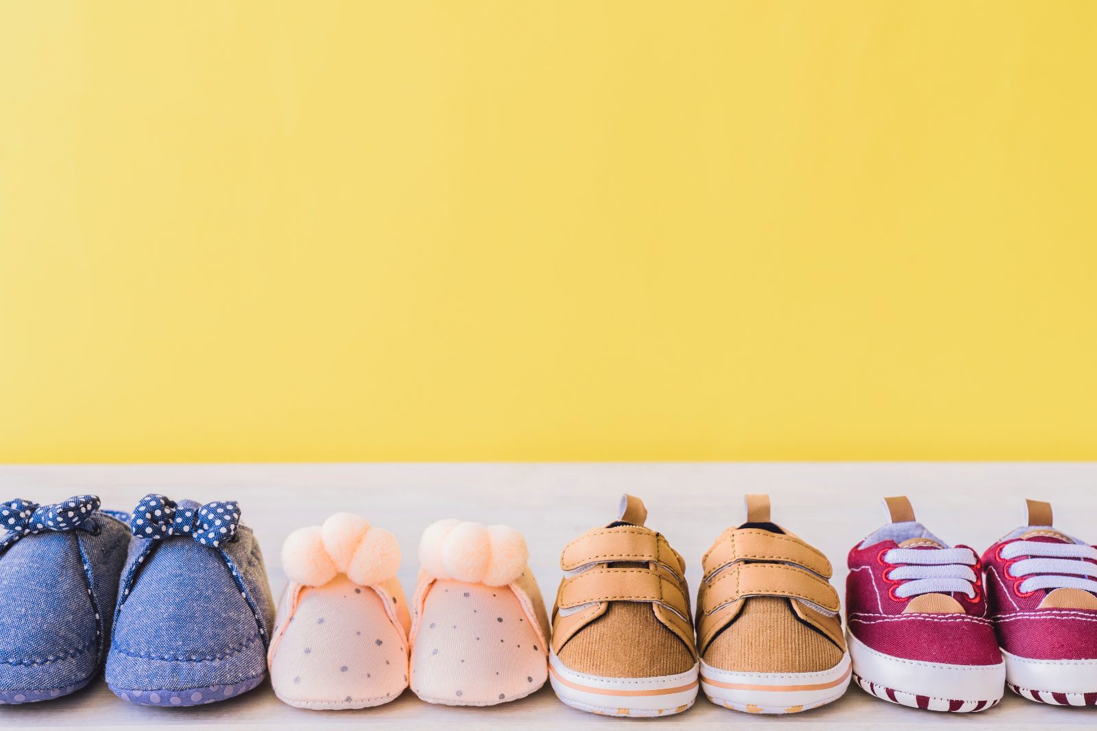 Pozycjonowanie sklepów z obuwiem dziecięcym - dziecko i kilka par butów w różnych rozmiarach