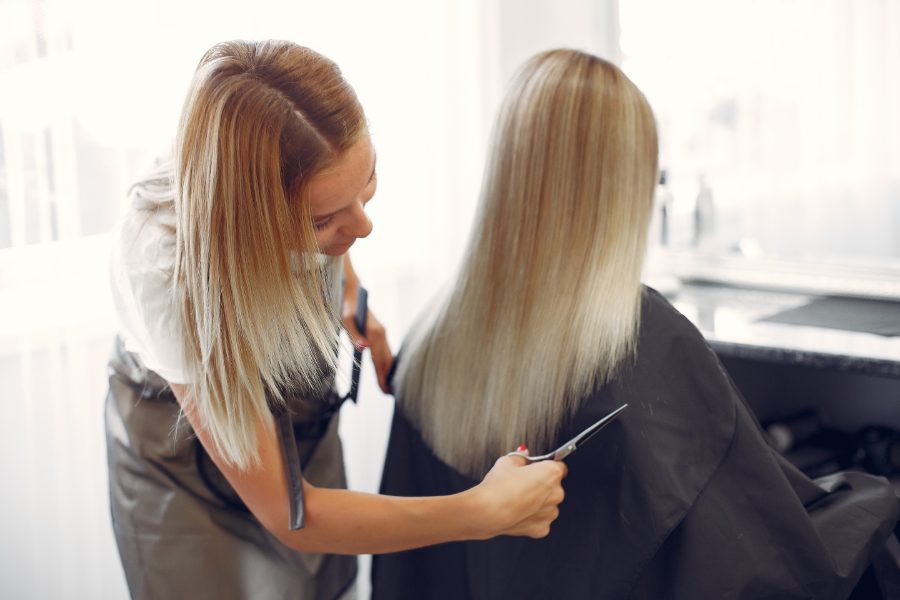 Pozycjonowanie salonów fryzjerskich - klientka w fotelu fryzjerskim podczas strzyżenia